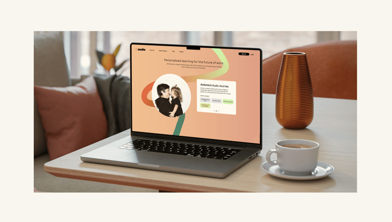 Shows a laptop open with the Audo website on the screen