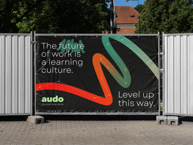 A poster on a fence showing Audo marketing materials. 